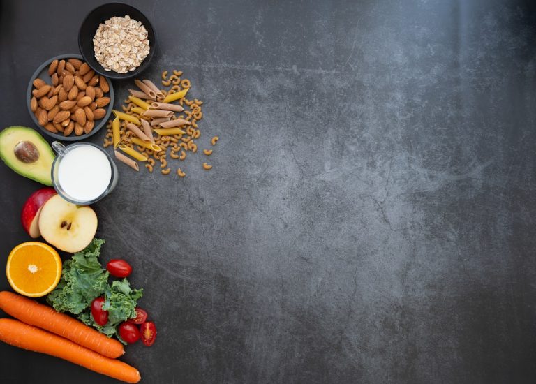 Aliments riches en magnésium : amandes, avocat, flocons d'avoine et légumes verts sur fond sombre