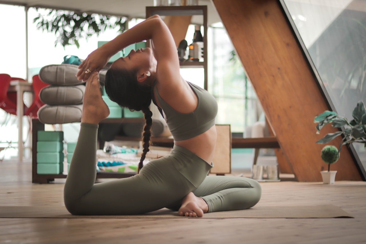 Yoga débutant : femme pratiquant une posture de yoga sur son tapis à la maison
