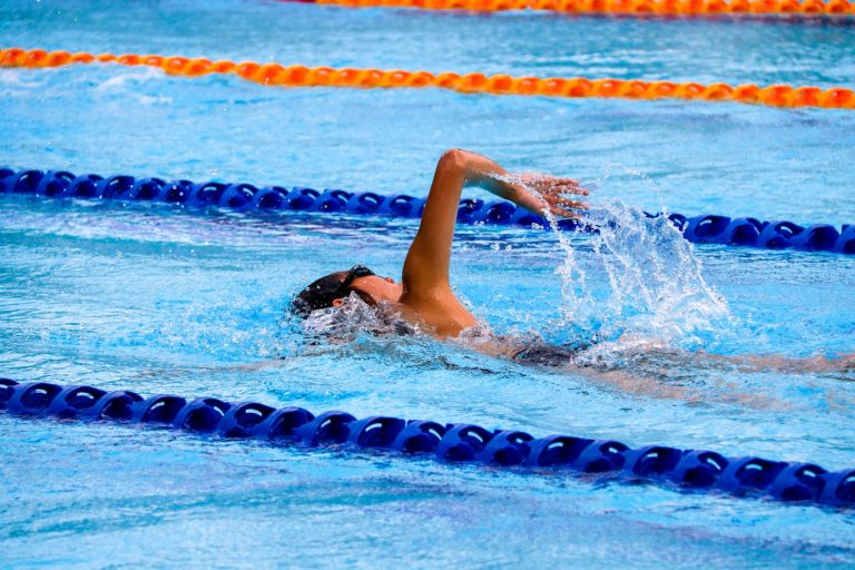 Bienfaits natation pour le corps féminin — femme nageant le crawl en piscine