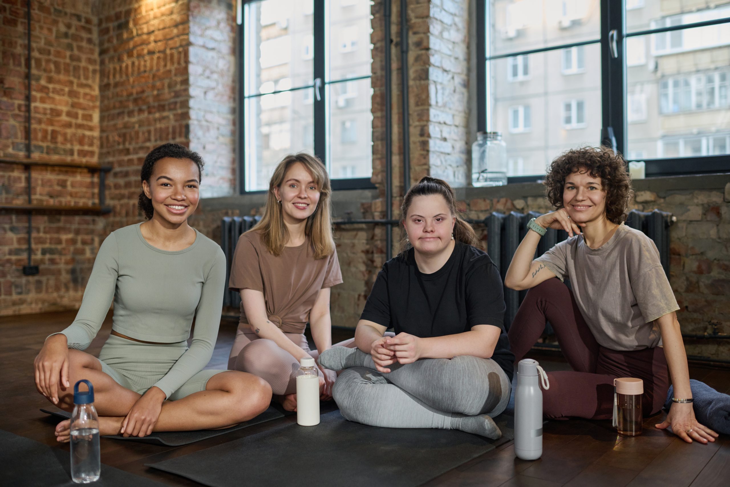 Groupe de femmes en sport, souriantes, symbolisant bien-être collectif et santé physique et mentale.