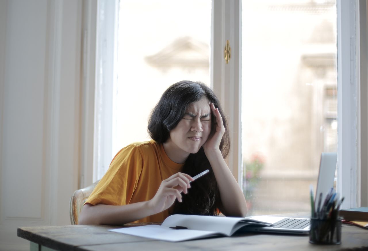 Cortisol élevé symptômes : femme stressée avec maux de tête