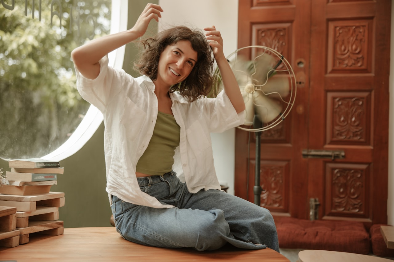 Bouffées de chaleur solutions naturelles — femme se rafraîchissant devant un ventilateur