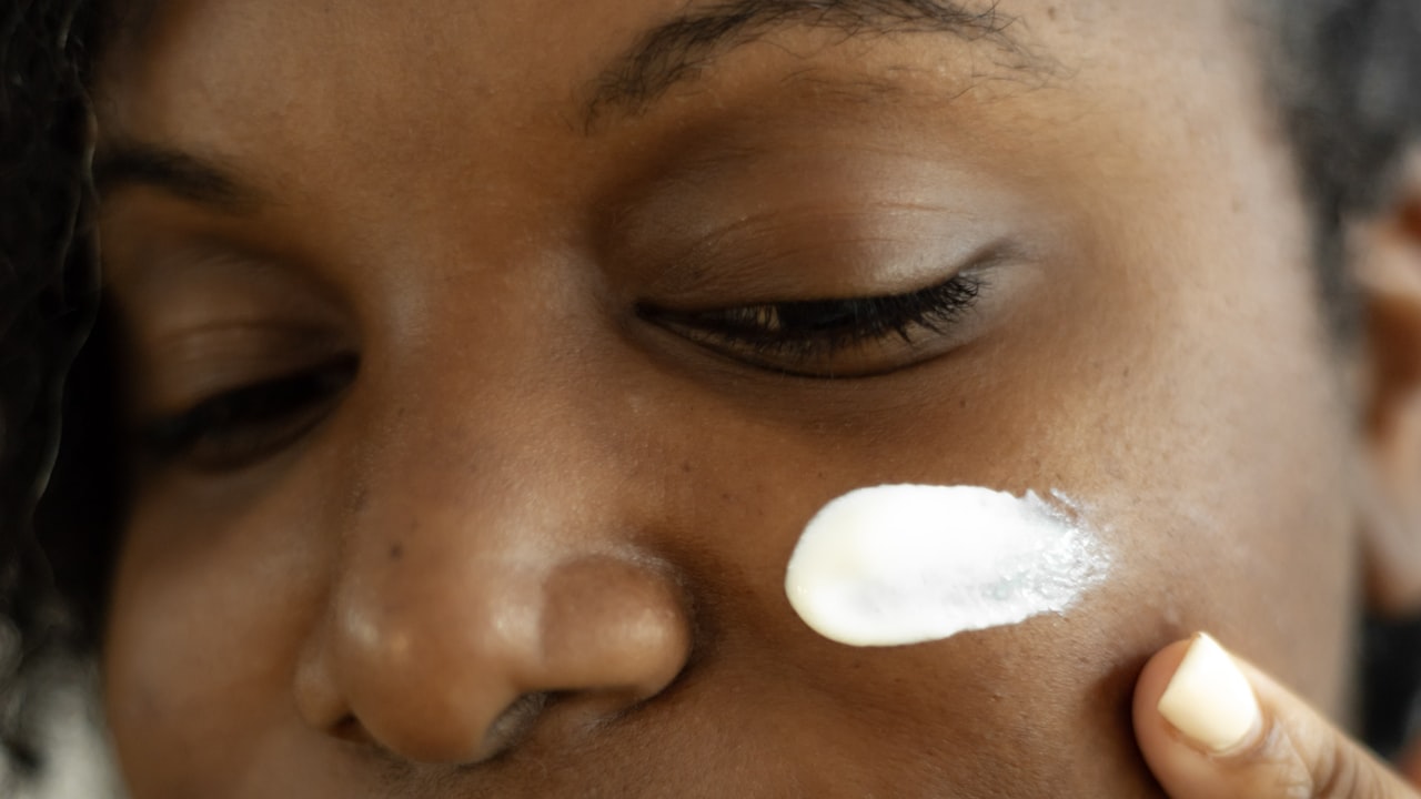 Rétinol comment l'utiliser — femme appliquant une crème au rétinol sur sa joue