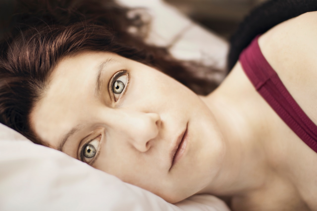 Se réveiller la nuit — femme allongée dans son lit, les yeux ouverts, incapable de se rendormir