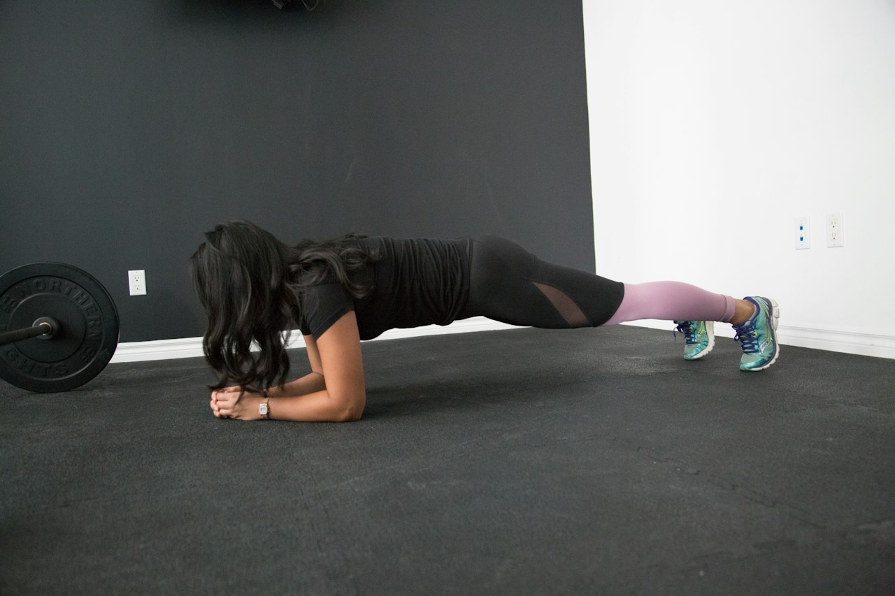 Exercices de gainage : femme en position de planche sur les avant-bras