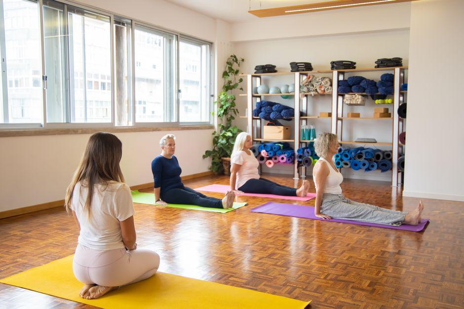 Professeur de yoga face à ses élèves lors d'un cours collectif dans un studio lumineux