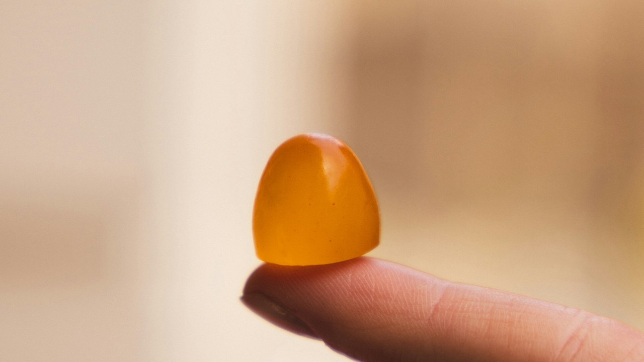 Un gummy au CB2 posé sur le bout du doigt, dosage fixe par bonbon