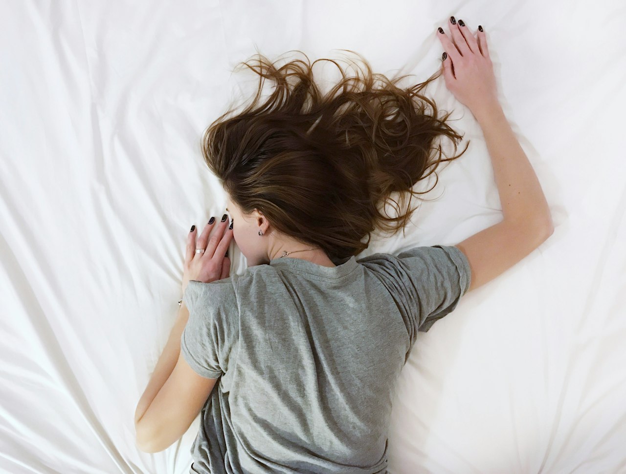 Mélatonine et sommeil : femme endormie paisiblement dans son lit